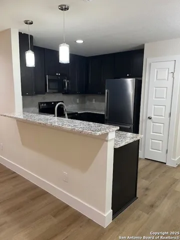 a kitchen with stainless steel appliances granite countertop a refrigerator and a stove