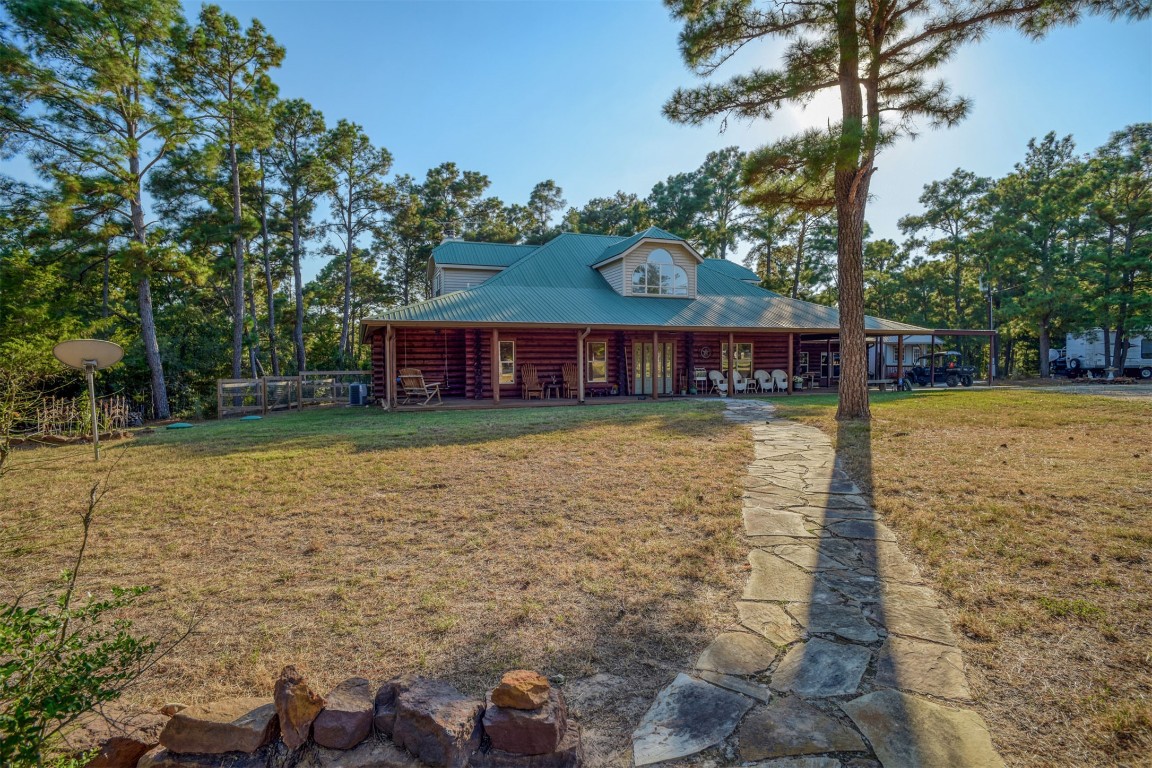271 Sandy Road, Unit B Rosanky, TX 78953 - Photo 1 of 1 Cabin with log siding, a metal roof, a front lawn, and a porch