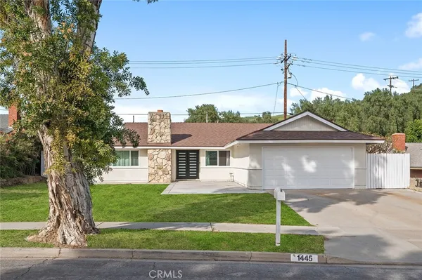 a front view of a house with a garden and plants