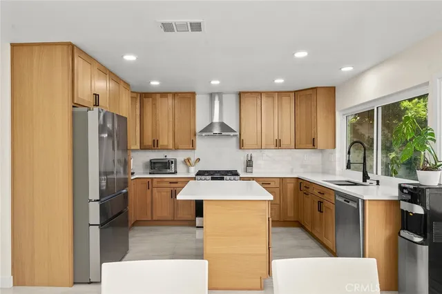 a kitchen with stainless steel appliances granite countertop sink stove refrigerator and cabinets