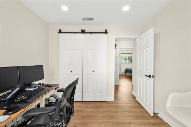 a view of a workspace with furniture and wooden floor