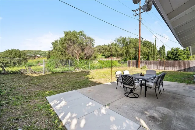 a view of a patio with table and chairs under an umbrella