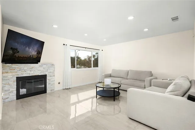 a living room with furniture a flat screen tv and a fireplace