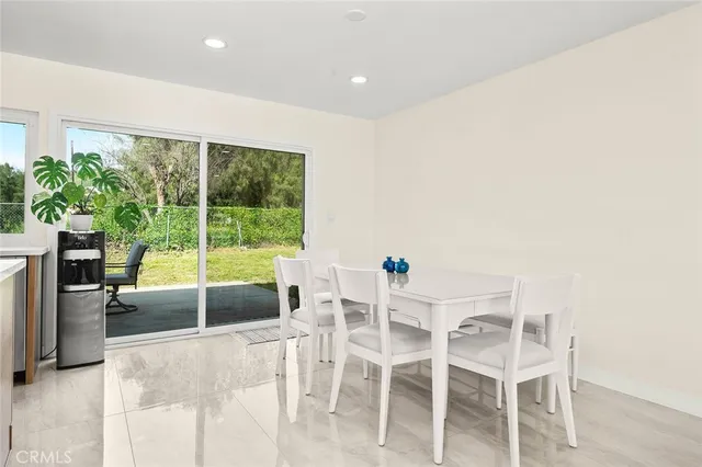 a dining room with furniture and a large window