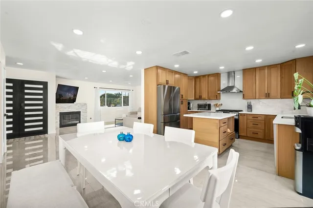 a large kitchen with kitchen island a stove a sink a refrigerator and cabinets