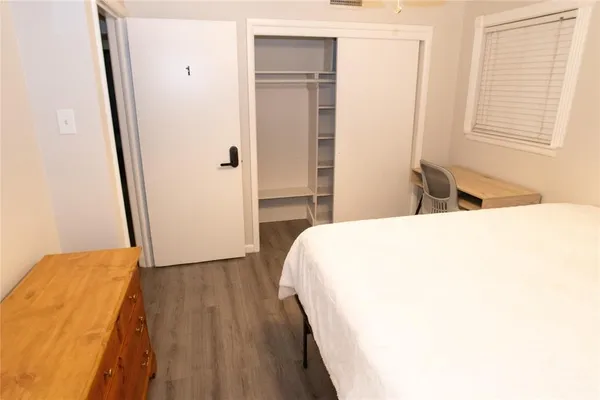 a bedroom with a bed and wooden floor