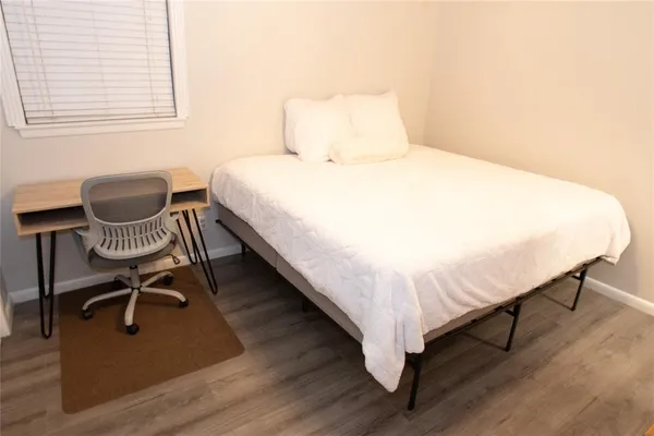 a large bed sitting in a bedroom next to a window and chair