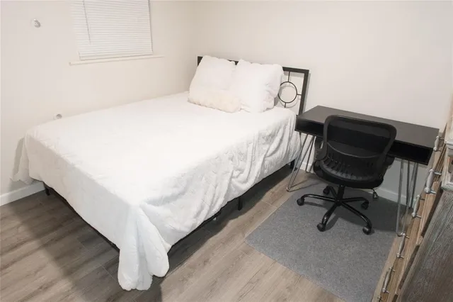 a large bed sitting in a bedroom next to a chair