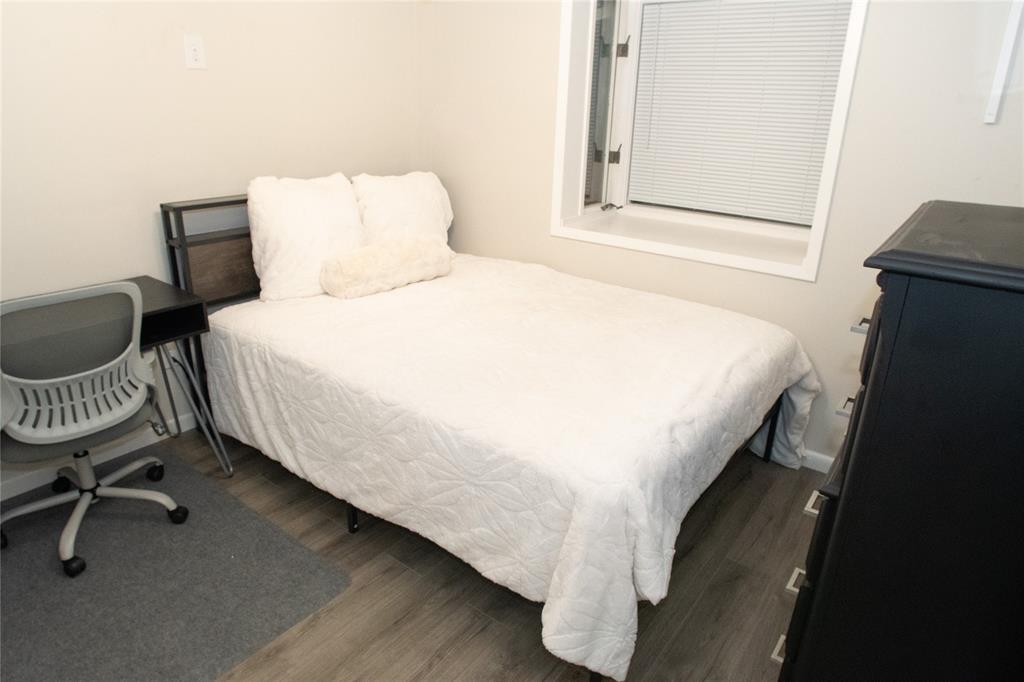 2129 Province Lane Dallas, TX 75228 - Photo 21 of 33 a bedroom with a bed a chair and a potted plant on the dresser