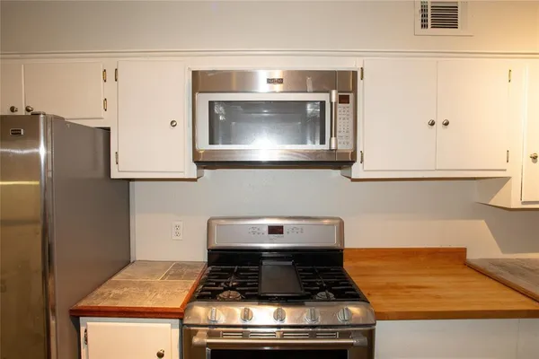 a stove top oven sitting inside of a kitchen