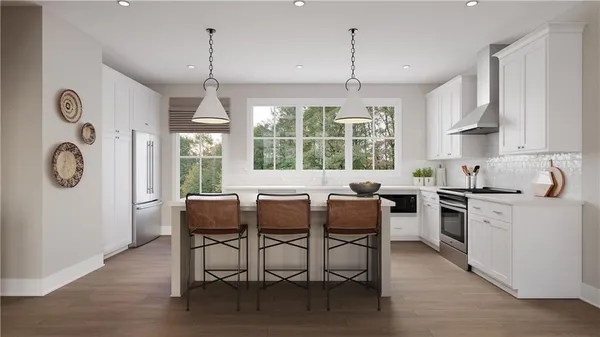 a kitchen with granite countertop a table chairs stove and white cabinets