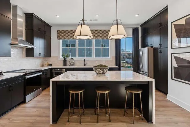 a kitchen with stainless steel appliances granite countertop a stove a refrigerator a sink dishwasher a oven with wooden cabinets and wooden floor