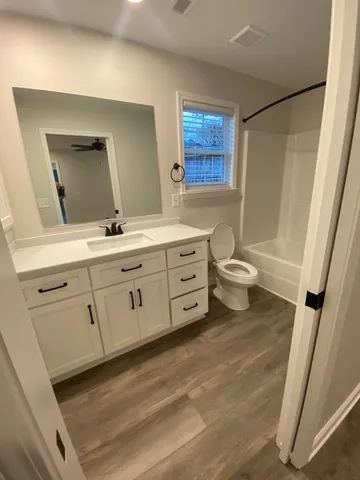 a bathroom with a double vanity sink a toilet and a mirror