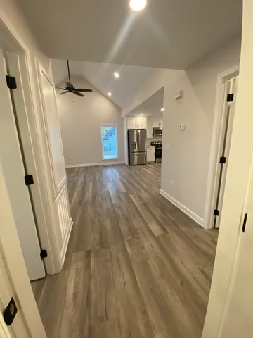 a view of empty room with wooden floor and window