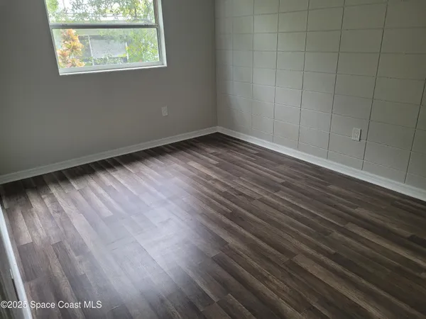 a view of an empty room with wooden floor