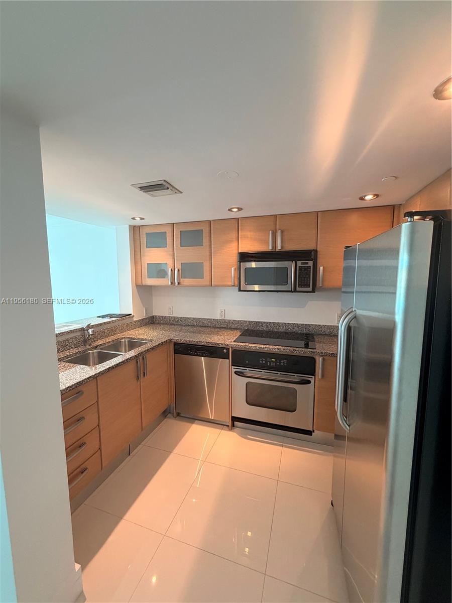 2101 Brickell Avenue, Unit 1504 Miami, FL 33129 - Photo 11 of 15 a kitchen with stainless steel appliances granite countertop a refrigerator and a stove