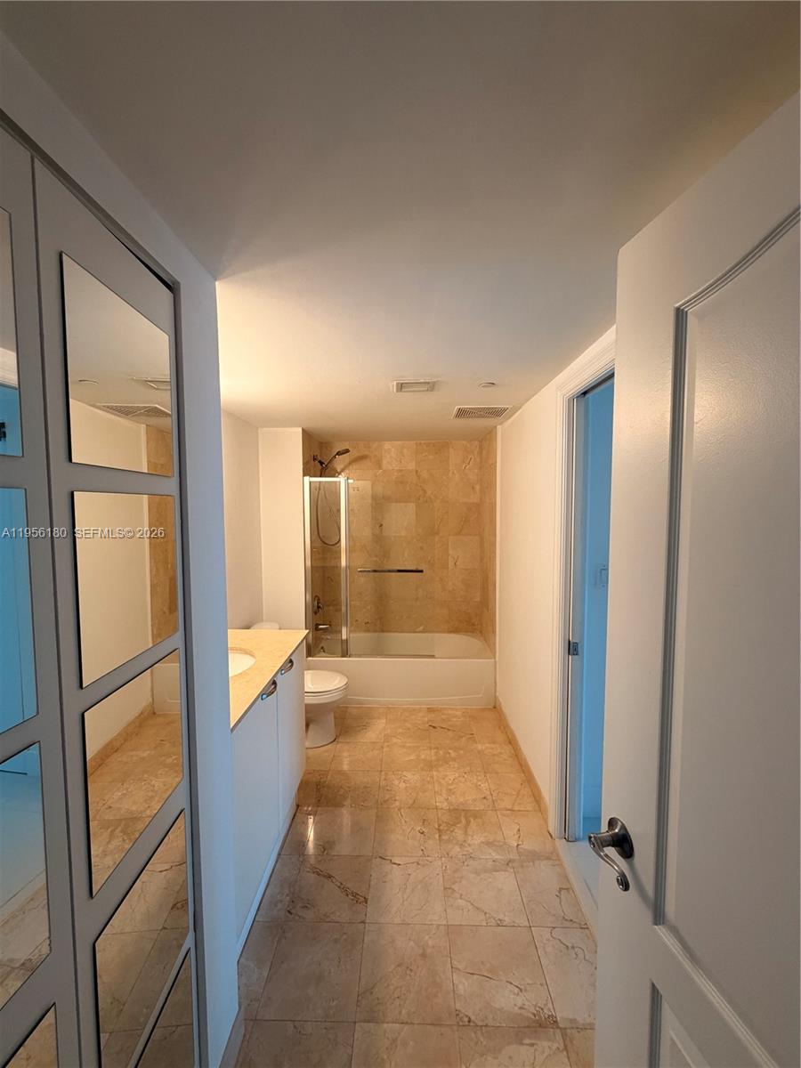 2101 Brickell Avenue, Unit 1504 Miami, FL 33129 - Photo 14 of 15 a bathroom with a tub shower and mirror