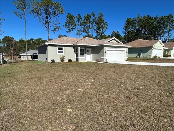 a front view of a house with a garden and yard