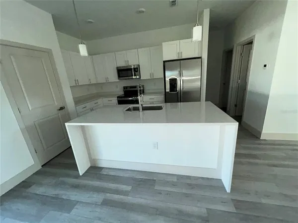 a kitchen with stainless steel appliances a refrigerator a sink a stove a microwave and cabinets