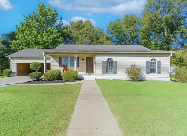 a front view of a house with a garden and yard