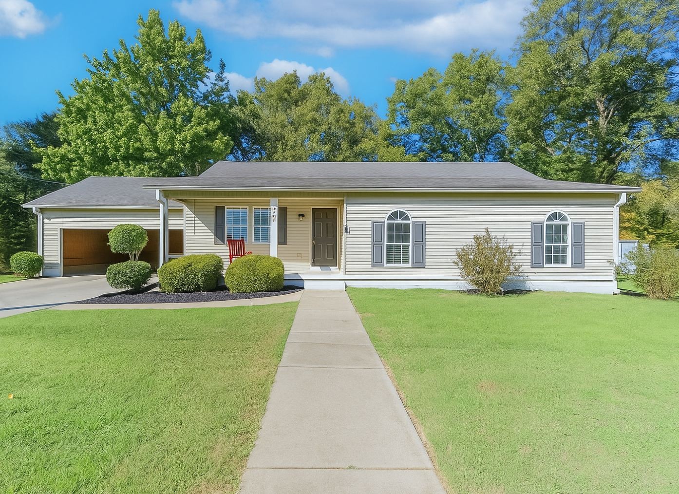 a front view of a house with a garden and yard