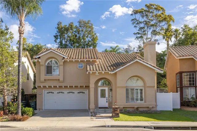 a front view of a house with a garden and a tree