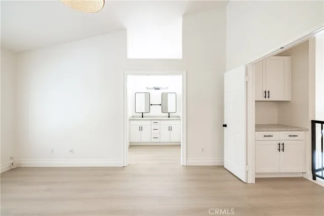 a view of a kitchen with white cabinets and wooden floor
