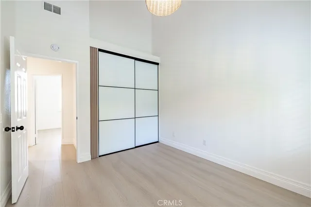 an empty room with wooden floor and mirror