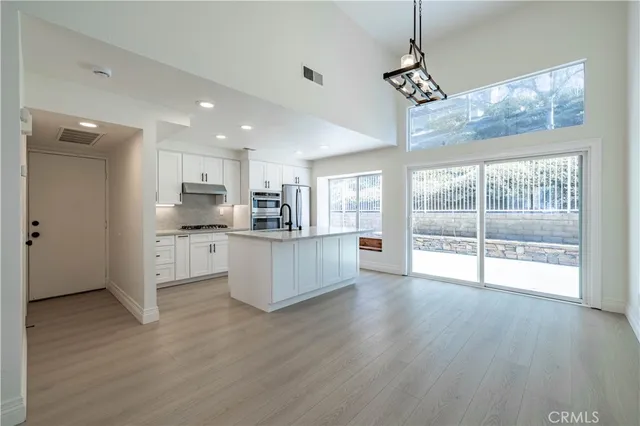 a view of kitchen with stainless steel appliances refrigerator oven and cabinets