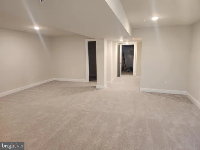 a view of an empty room with closet and bathroom