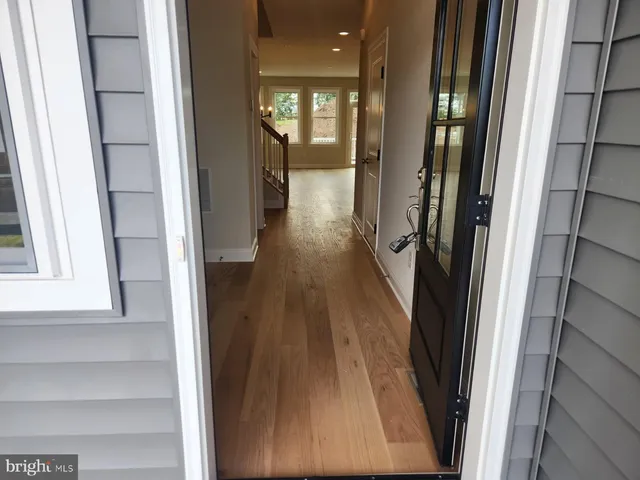 a view of a hallway with wooden floor and staircase