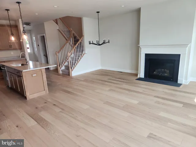 a view of a livingroom with wooden floor and a fireplace