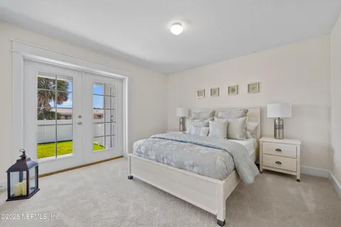 a spacious bedroom with a bed a dresser and window