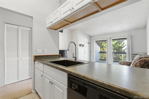 a kitchen with granite countertop a sink window and cabinets