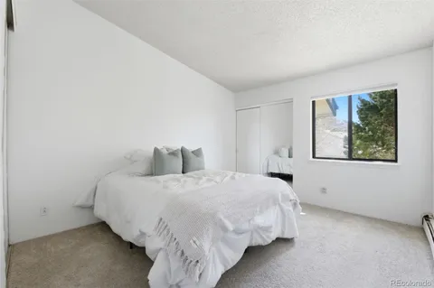 a large bed sitting in a bedroom next to a window