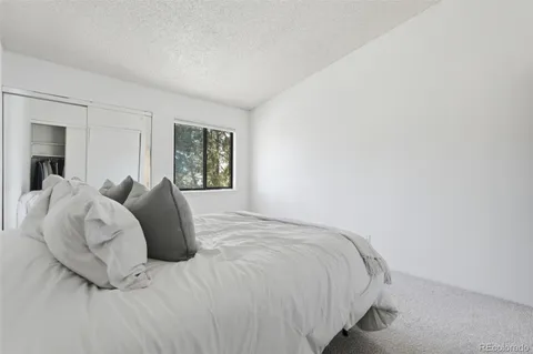 a large bed sitting in a bedroom next to a window