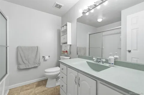 a bathroom with a sink a toilet and a large mirror