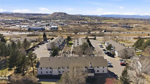 an aerial view of residential building with parking and yard
