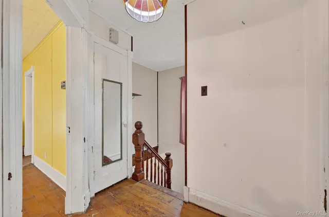 a view of a hallway with wooden floor and closet