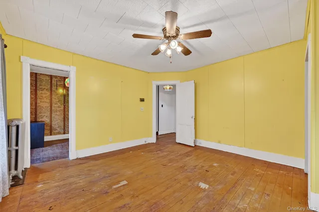 a view of a big room with a ceiling fan and a window