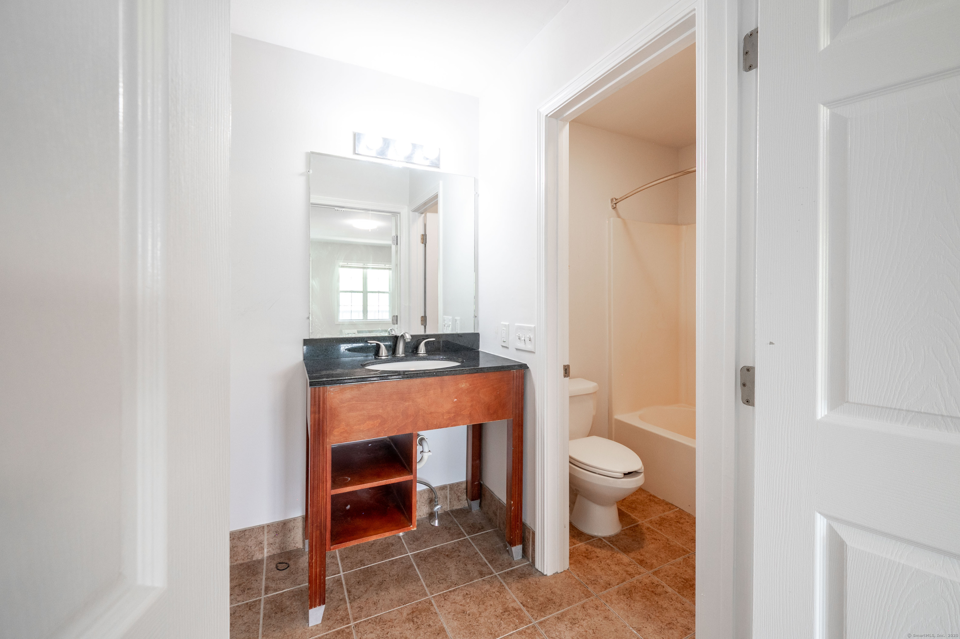 1030 Federal Road, Unit 201 Brookfield, CT 06804 - Photo 18 of 20 a room with a toilet a sink and a mirror