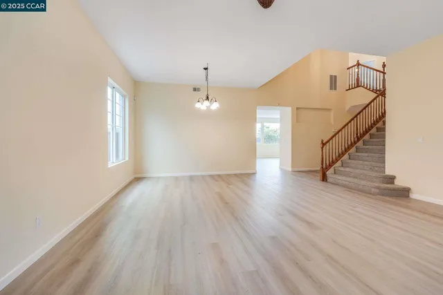a view of a livingroom with wooden floor and stairs