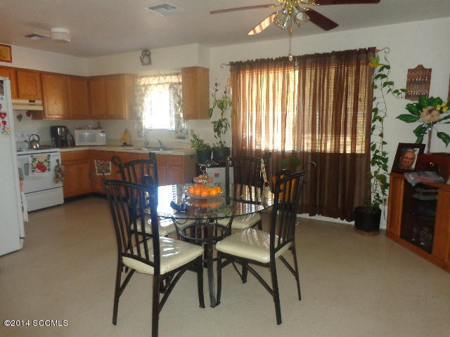 418 Curry Street Rio Rico, AZ 85648 - Photo 4 of 11 a kitchen with a table chairs sink and cabinets