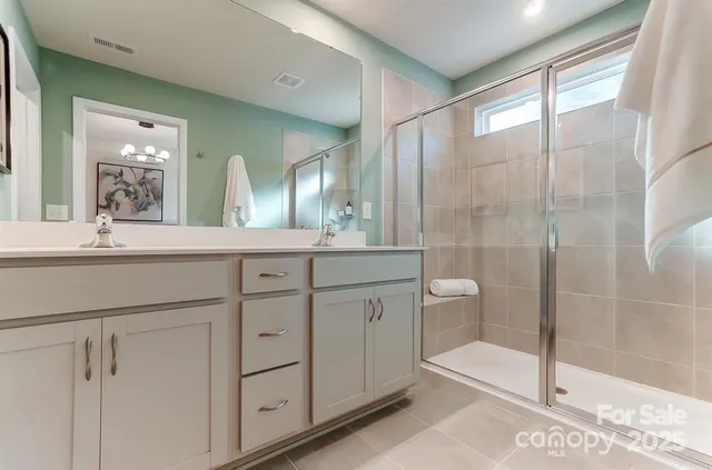 a bathroom with a double vanity sink toilet and shower