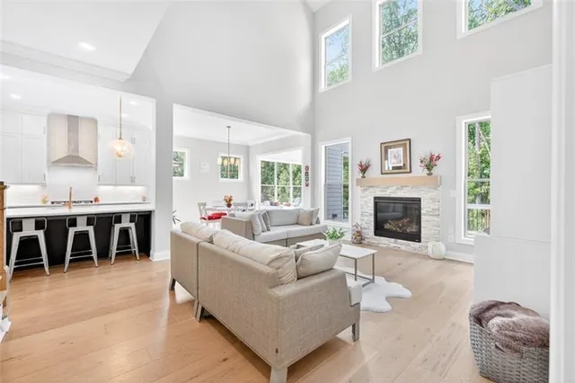 a large kitchen with kitchen island a stove a sink a refrigerator and white cabinets with wooden floor