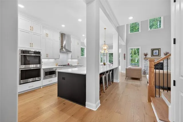 a large kitchen with stainless steel appliances kitchen island a large counter space a sink and a wooden floors