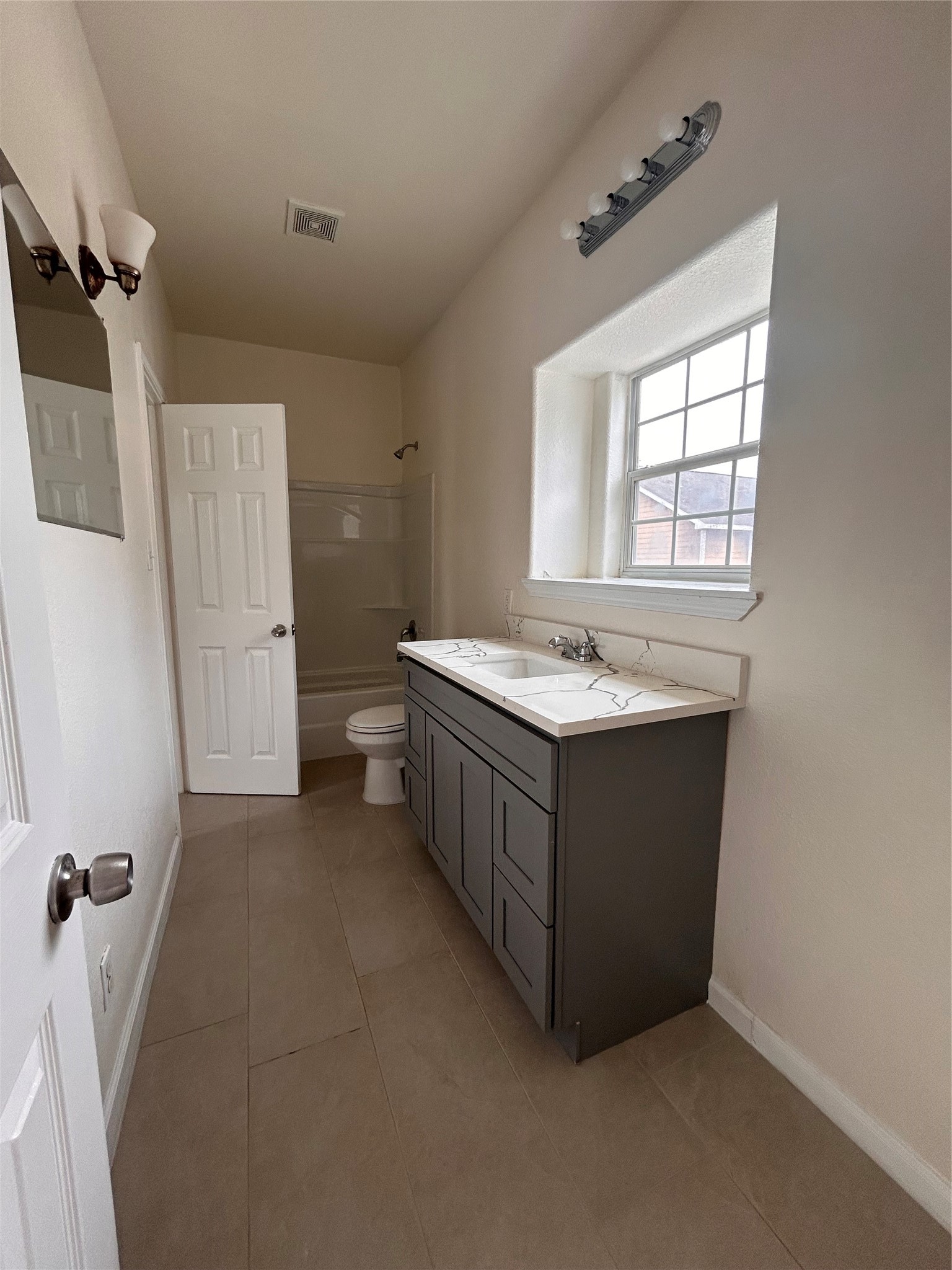6841 Larkstone Street, Unit B Houston, TX 77028 - Photo 3 of 11 a bathroom with a double vanity sink a mirror and a bathtub