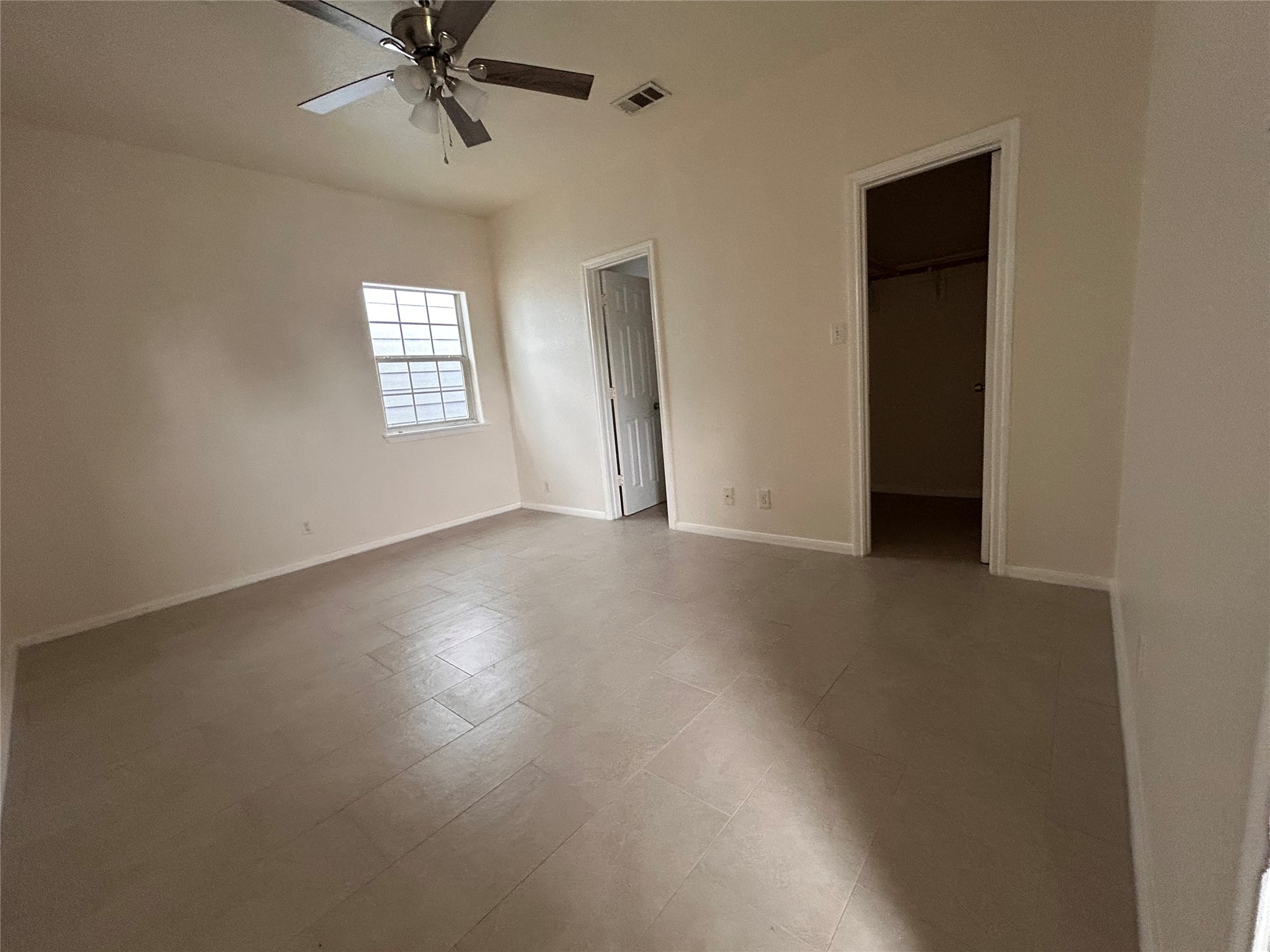 6841 Larkstone Street, Unit B Houston, TX 77028 - Photo 6 of 11 an empty room with a window and a ceiling fan