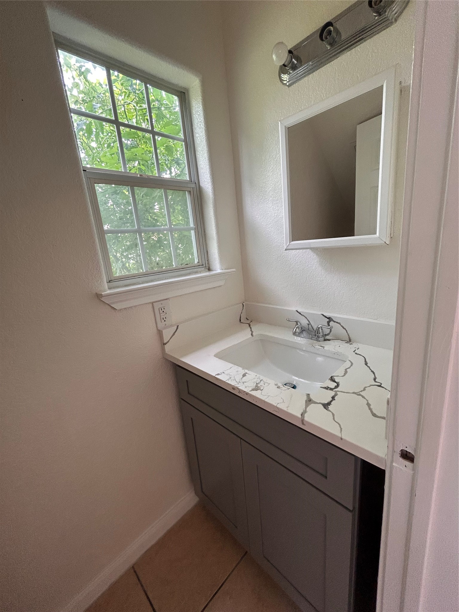6841 Larkstone Street, Unit B Houston, TX 77028 - Photo 7 of 11 a bathroom with a granite countertop sink a mirror and a window
