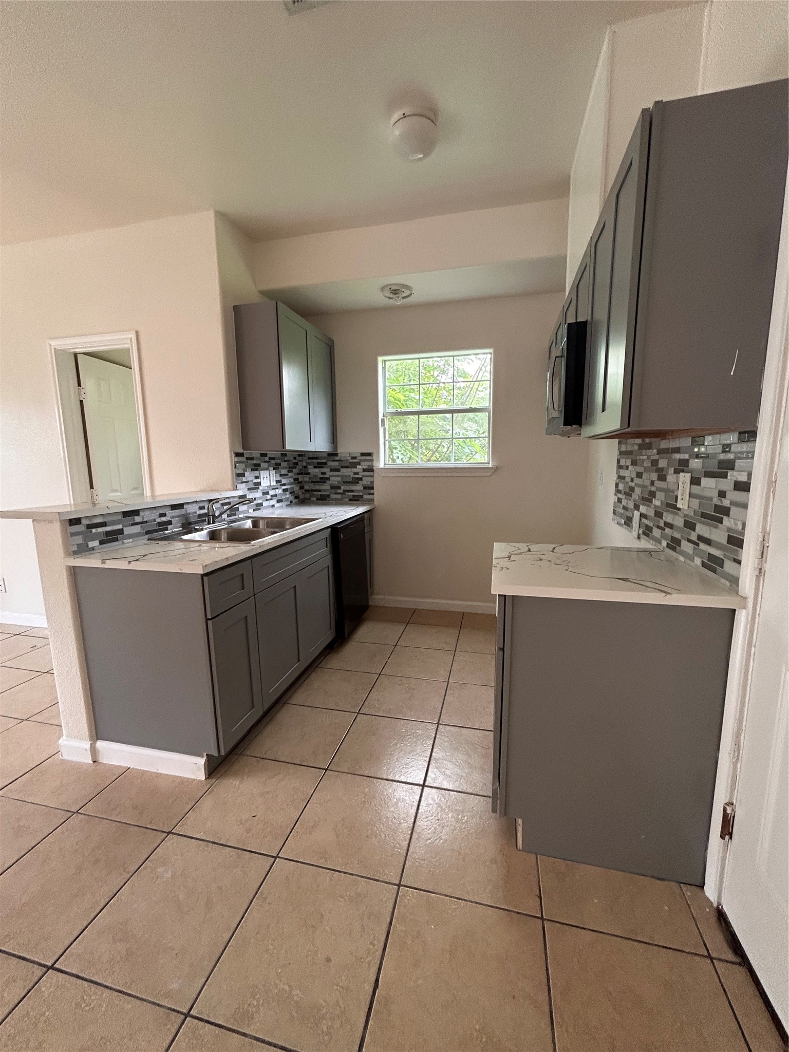 6841 Larkstone Street, Unit B Houston, TX 77028 - Photo 8 of 11 a kitchen with stainless steel appliances granite countertop a stove a sink and a microwave